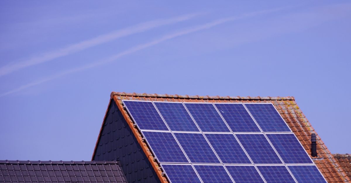 Solaranlage auf einem Hausdach bei strahlend blauem Sommerhimmel und hohem Sonnenstand
